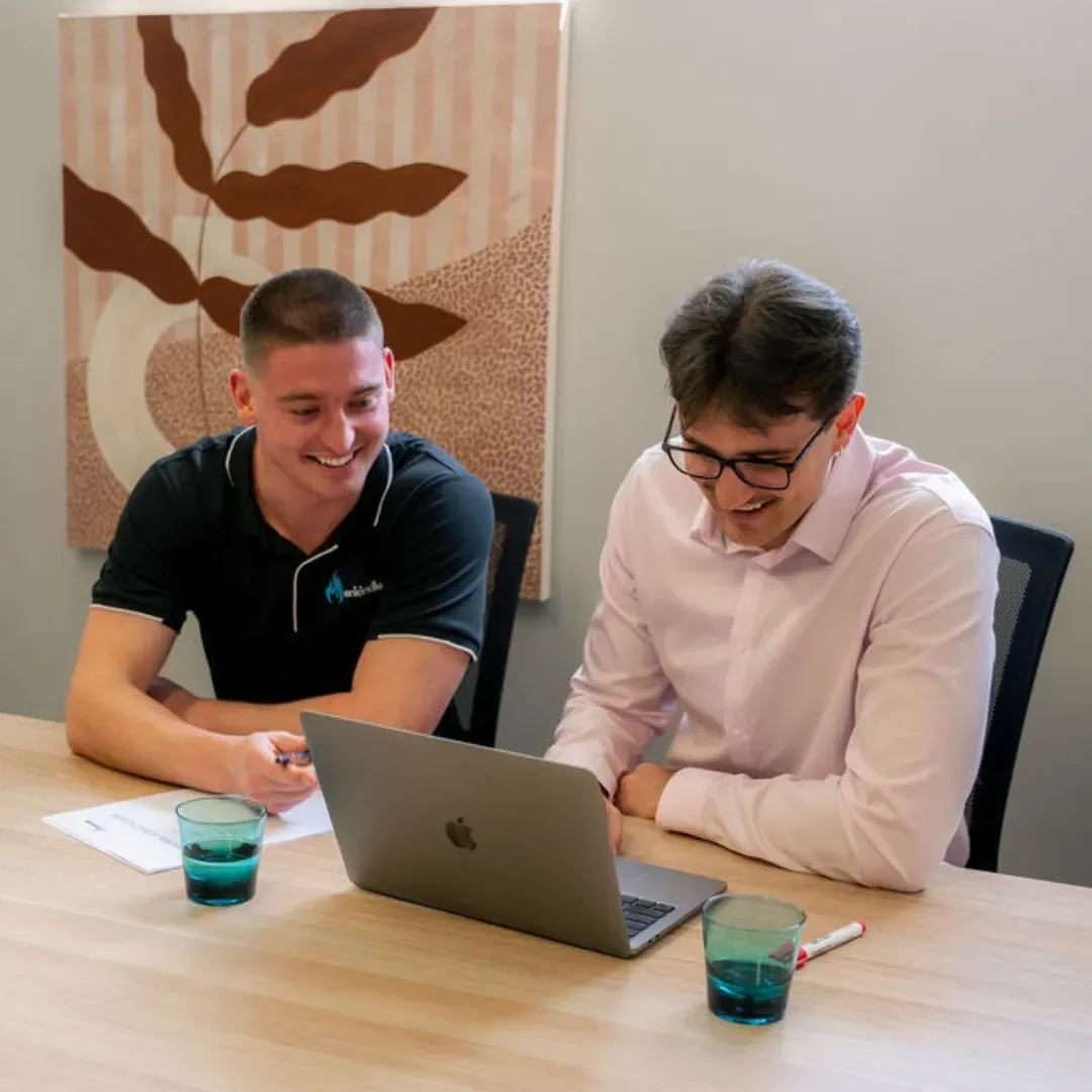 Kobi Martin and Harvie Williams, the two founders of Enkindle Group, at a laptop in the Perth office